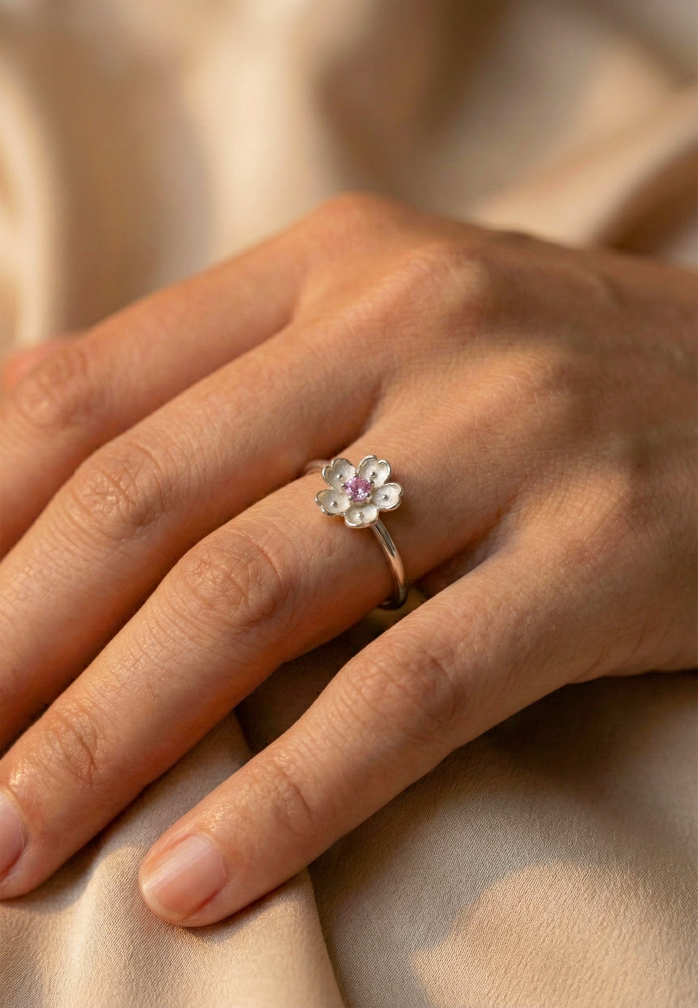 Zamari silver flower ring on hand showcased by online dainty jewelry boutique