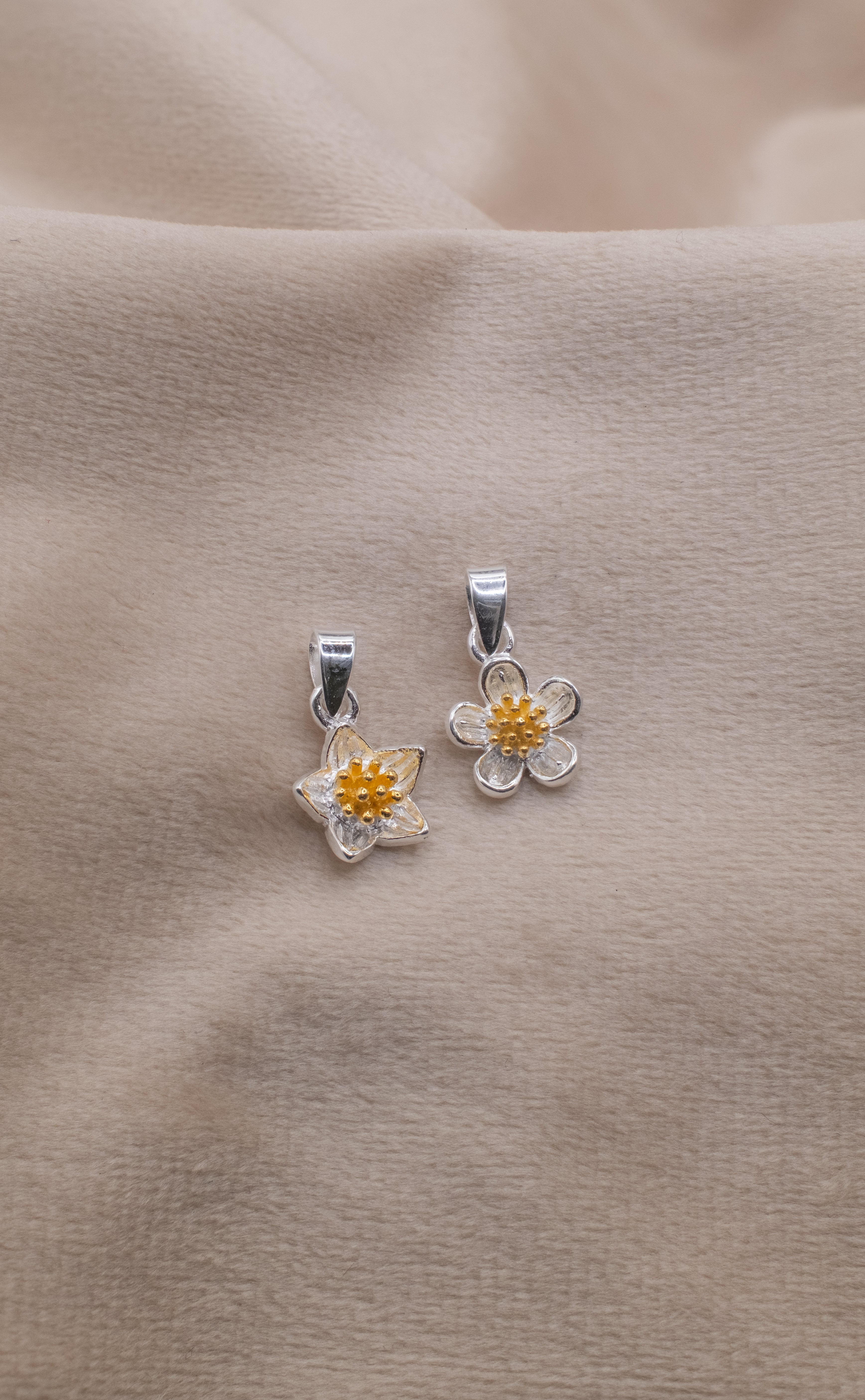 Silver flower-shaped necklace pendants with yellow centers from Zamari online dainty jewelry boutique