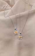 Zamari silver flower pendant necklaces displayed on beige fabric from online dainty jewelry boutique