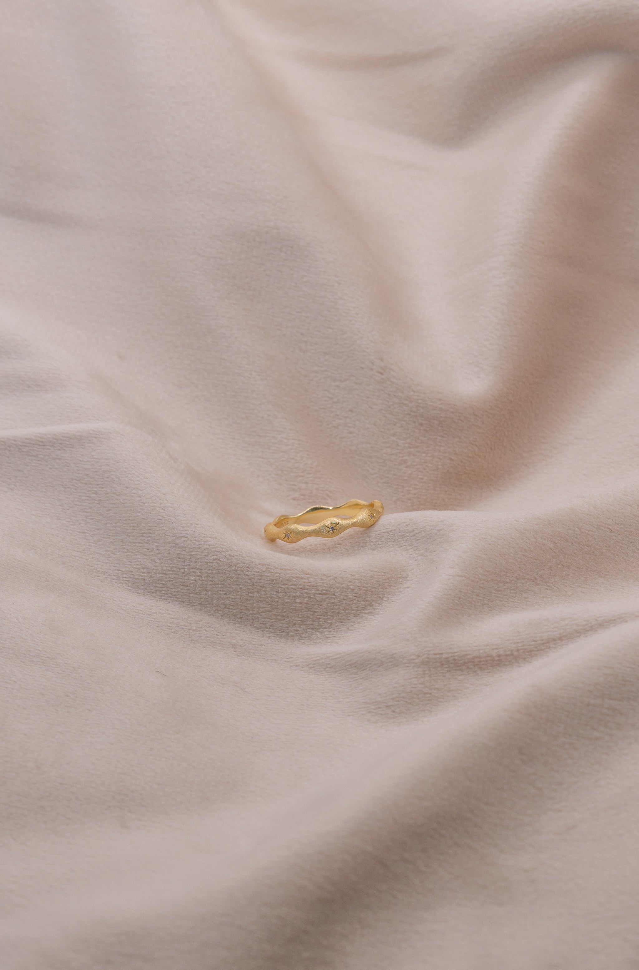 Zamari gold ring with wave design on soft fabric from online dainty jewelry boutique
