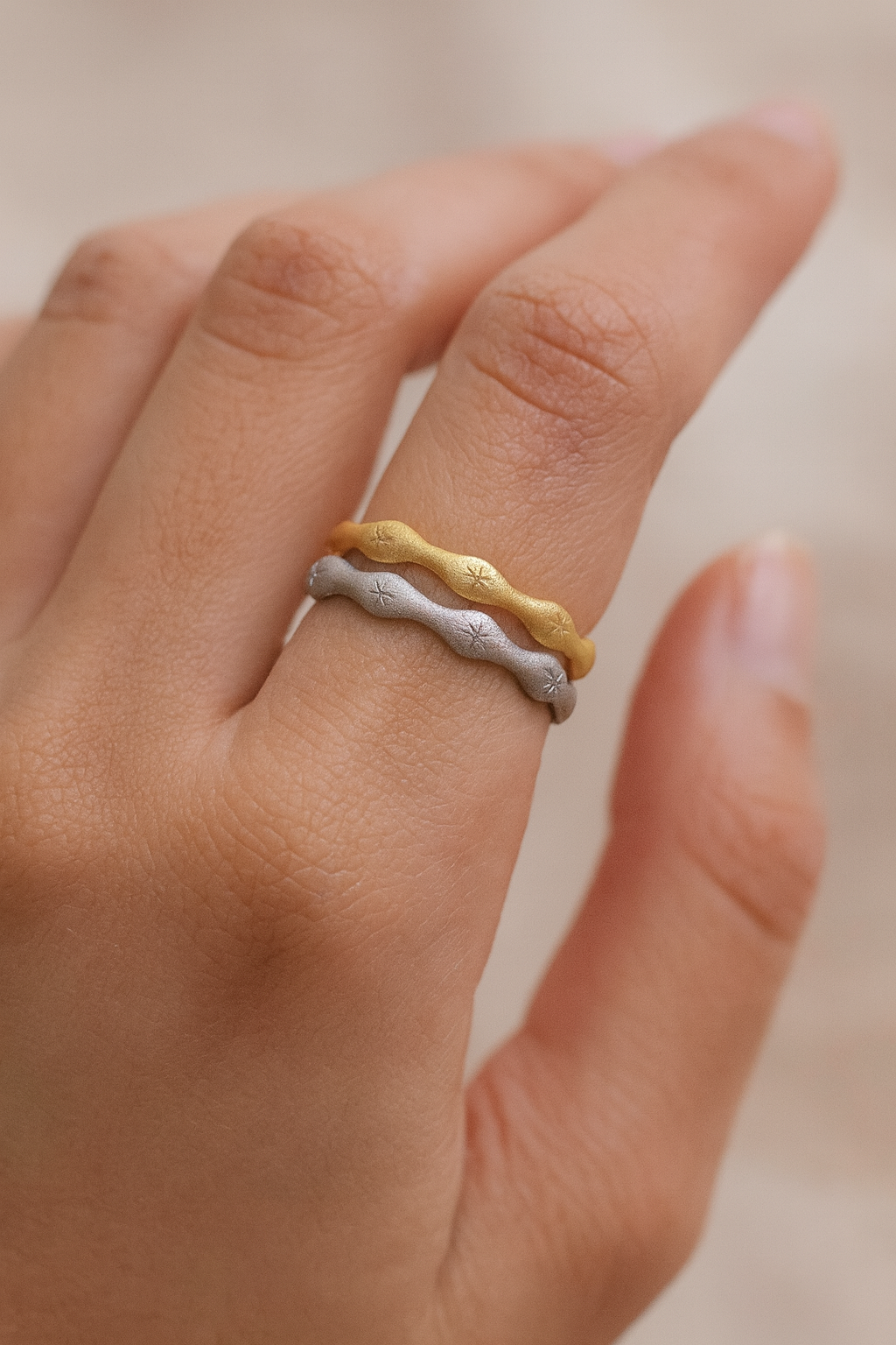 Gold and silver wavy stackable rings on finger from Zamari online dainty jewelry boutique