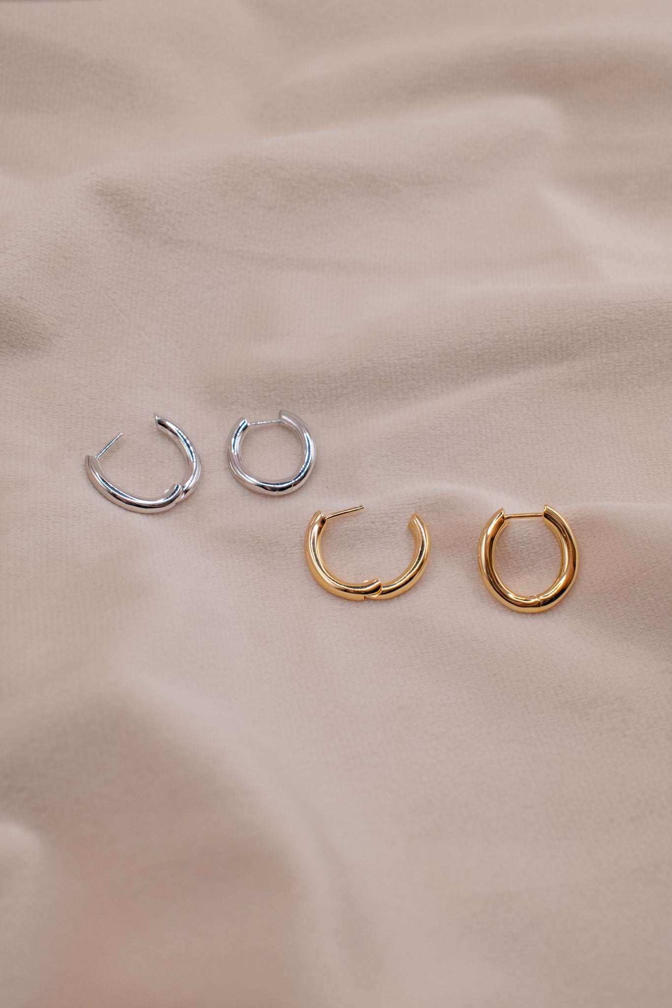 Zamari small hoop earrings in gold and silver tones showcasing sterling silver jewelry on beige fabric