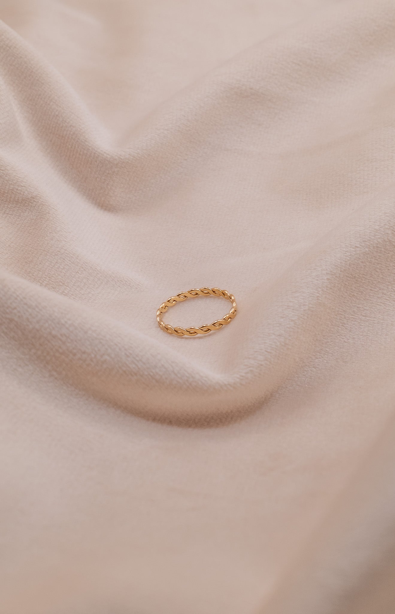 Zamari gold twisted ring displayed on soft beige fabric Sterling Silver Jewelry