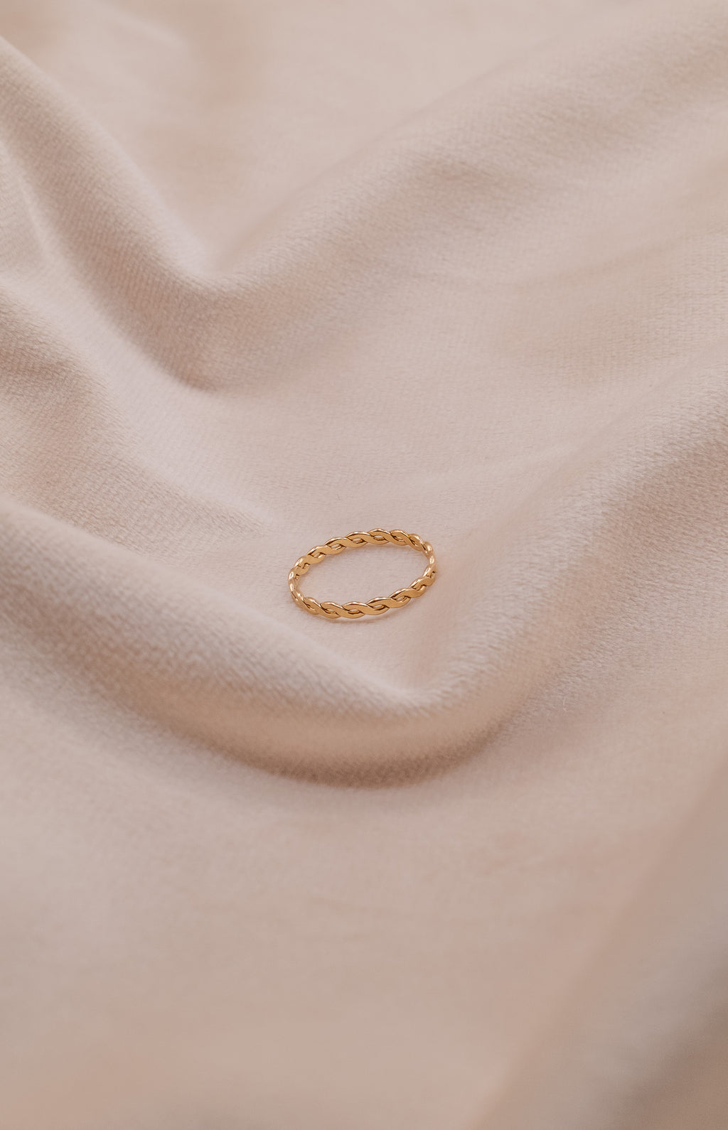 Zamari gold twisted ring displayed on soft beige fabric Sterling Silver Jewelry