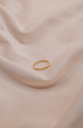Zamari gold twisted ring displayed on soft beige fabric Sterling Silver Jewelry