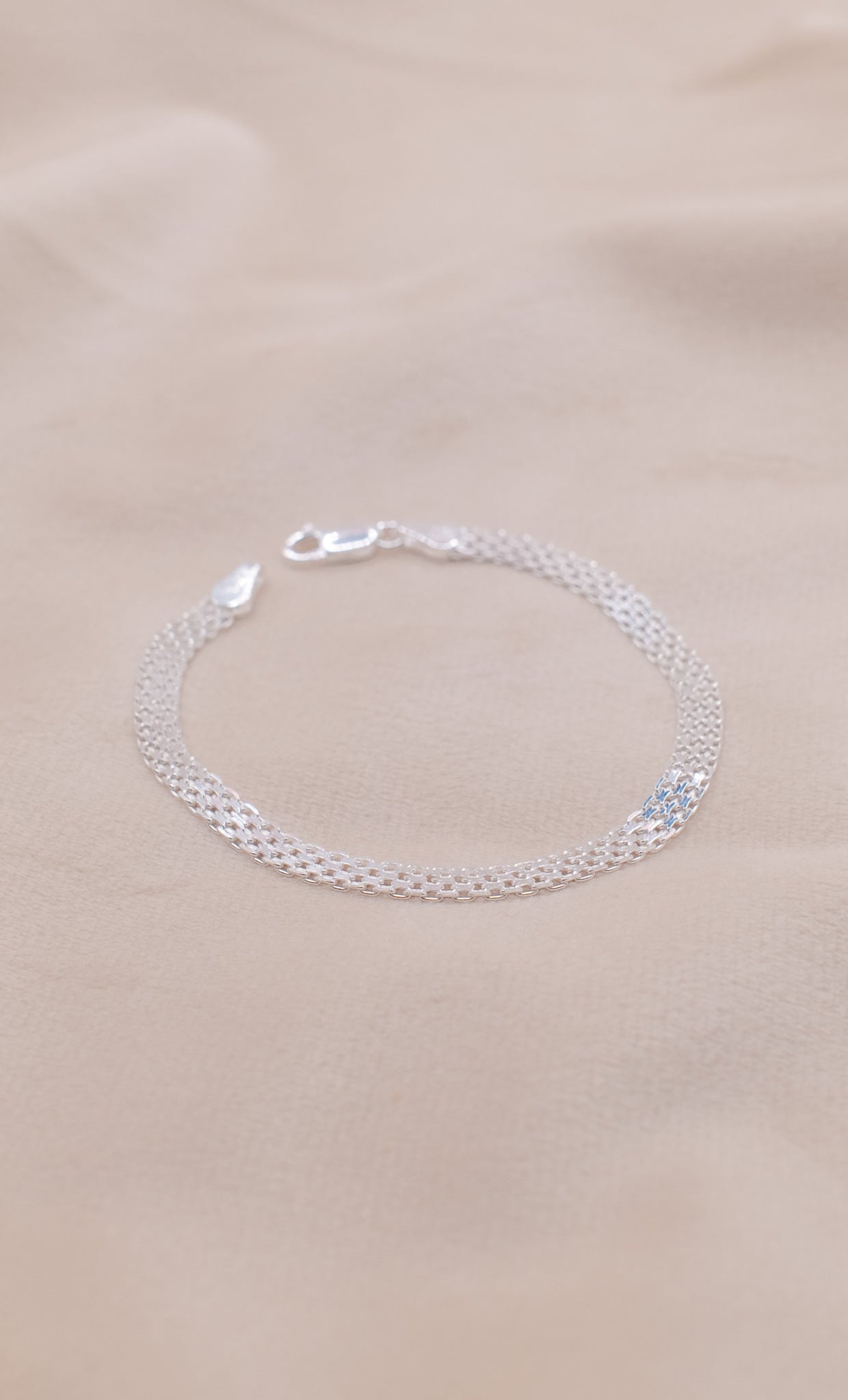 Zamari delicate sterling silver bracelet on soft beige fabric showcasing sterling silver jewelry