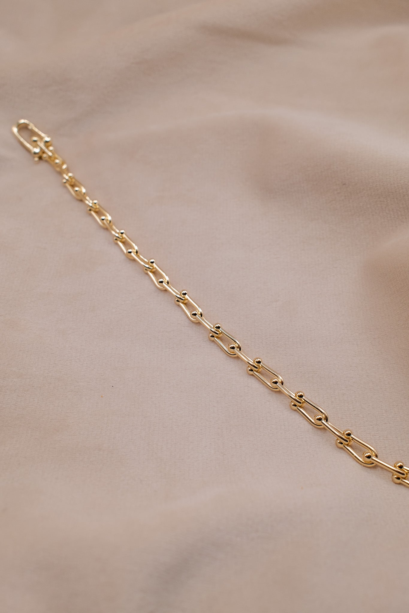 Zamari gold chain bracelet on beige fabric featuring elegant design Sterling Silver Jewelry
