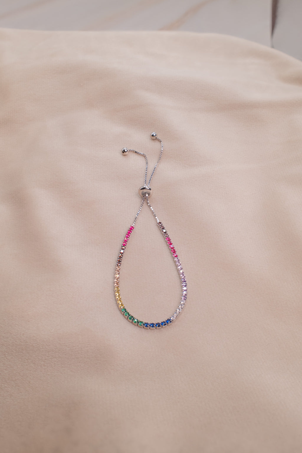 Zamari sterling silver jewelry bracelet with colorful gemstones and adjustable chain on beige fabric