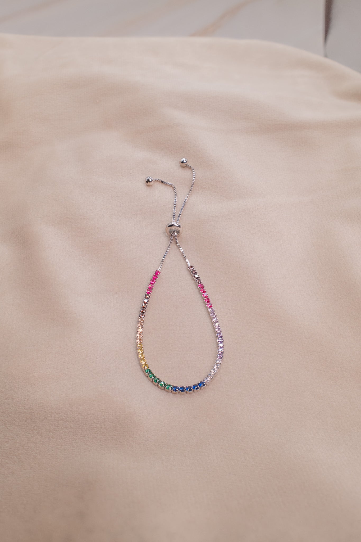 Zamari sterling silver jewelry bracelet with colorful gemstones and adjustable chain on beige fabric