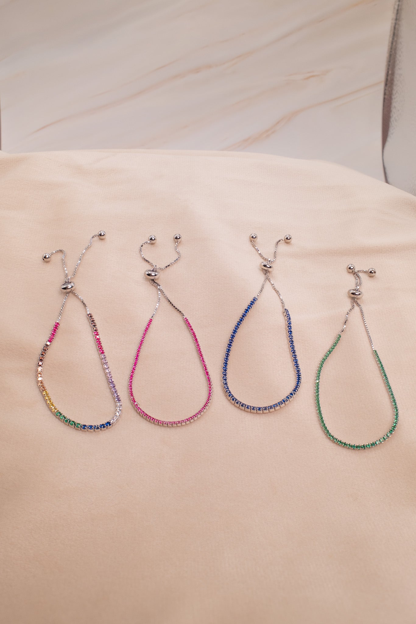 Zamari colorful adjustable bracelets made with sterling silver jewelry beads displayed on fabric