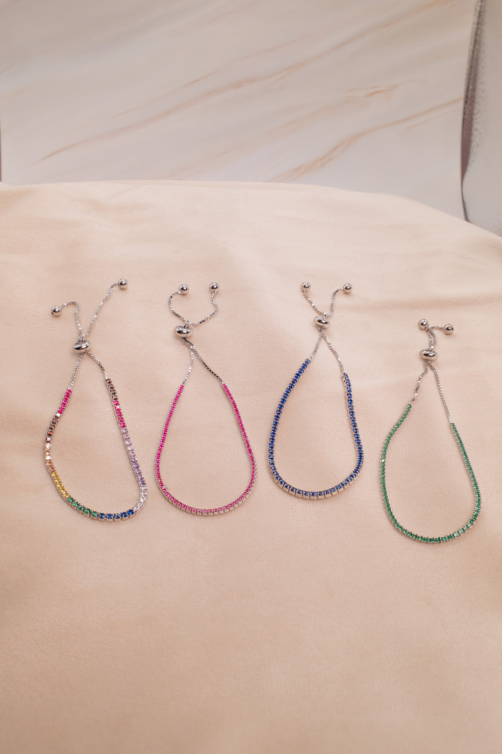 Zamari colorful adjustable bracelets made with sterling silver jewelry beads displayed on fabric